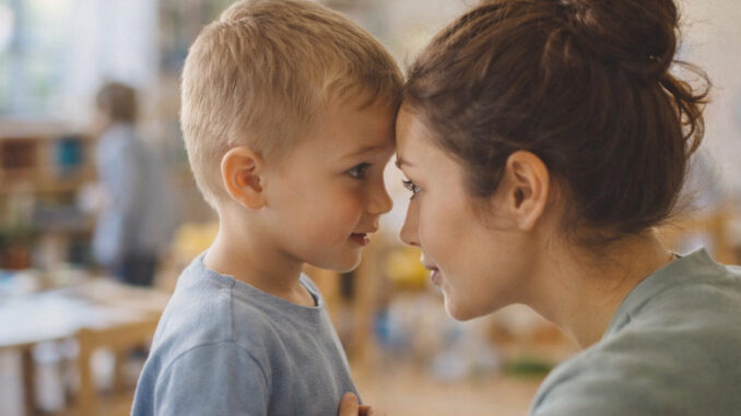 Ein Kind spricht vertraulich mit einer pädagogischen Fachkraft in einer Kita – Moment des Zuhörens und Vertrauens im Alltag der Kinderschutzarbeit.